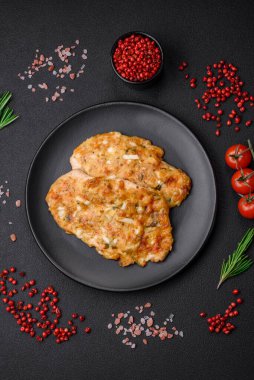 Lezzetli kızarmış tavuk göğsü hardal, tuz, baharat ve peynirli koyu beton arka planda.