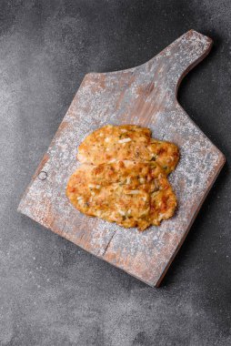 Lezzetli kızarmış tavuk göğsü hardal, tuz, baharat ve peynirli koyu beton arka planda.