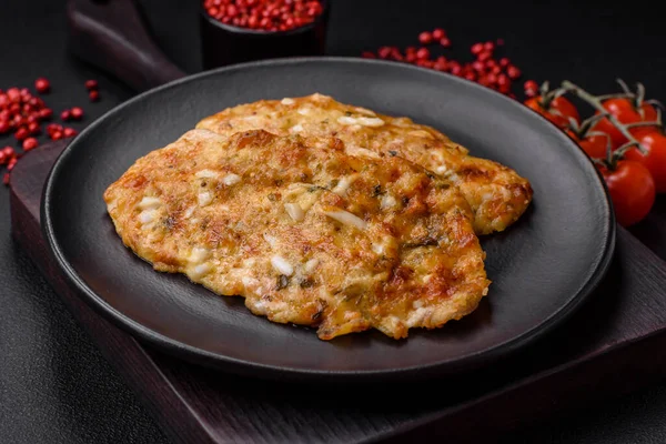 stock image Delicious fried chicken breast in batter with mustard, salt, spices and cheese on a dark concrete background