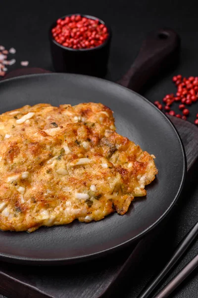 stock image Delicious fried chicken breast in batter with mustard, salt, spices and cheese on a dark concrete background