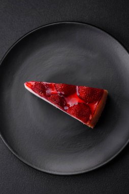 Çilekli, şuruplu ve desenli beton arkaplanlı peynirli leziz taze cheesecake.