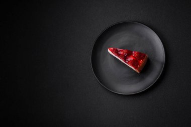 Çilekli, şuruplu ve desenli beton arkaplanlı peynirli leziz taze cheesecake.