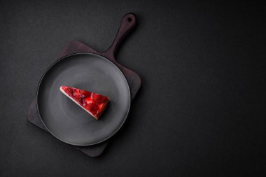 Çilekli, şuruplu ve desenli beton arkaplanlı peynirli leziz taze cheesecake.