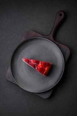 Çilekli, şuruplu ve desenli beton arkaplanlı peynirli leziz taze cheesecake.