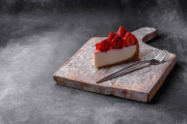 Çilekli, şuruplu ve desenli beton arkaplanlı peynirli leziz taze cheesecake.