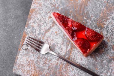 Çilekli, şuruplu ve desenli beton arkaplanlı peynirli leziz taze cheesecake.