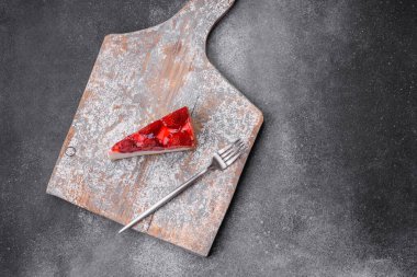 Çilekli, şuruplu ve desenli beton arkaplanlı peynirli leziz taze cheesecake.