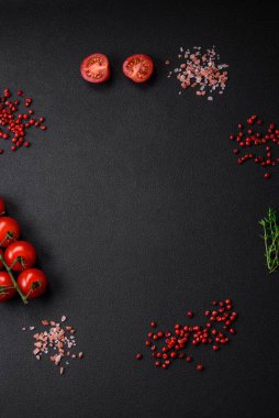 Koyu beton zeminde domates, tuz, baharat ve otlar pişirmek için gerekli malzemeler.