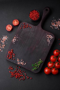 Koyu beton zeminde domates, tuz, baharat ve otlar pişirmek için gerekli malzemeler.