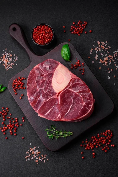 stock image Fresh beef ossobuco steak with salt, spices and herbs on textured concrete background