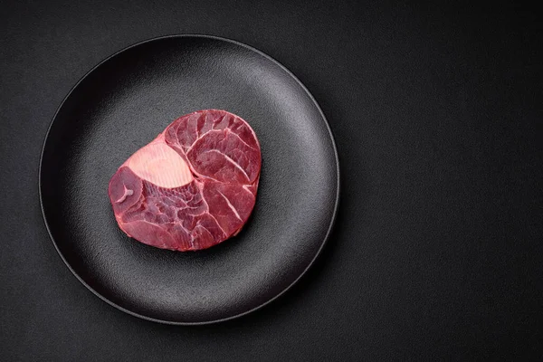 stock image Fresh beef ossobuco steak with salt, spices and herbs on textured concrete background