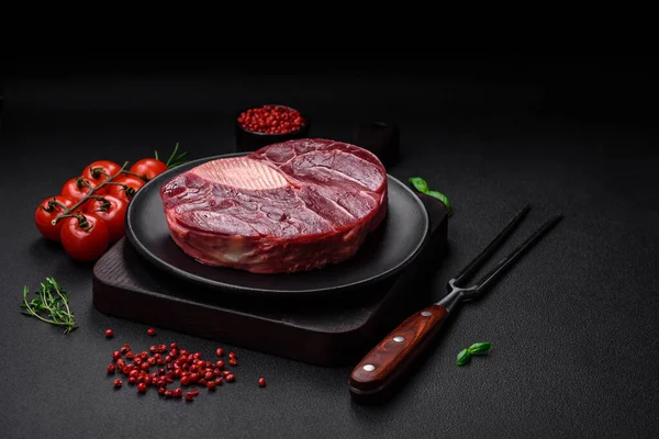 stock image Fresh beef ossobuco steak with salt, spices and herbs on textured concrete background