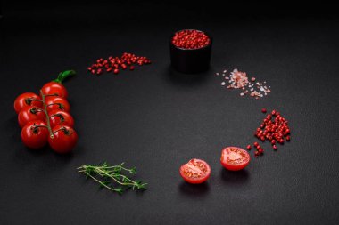 Koyu beton zeminde domates, tuz, baharat ve otlar pişirmek için gerekli malzemeler.