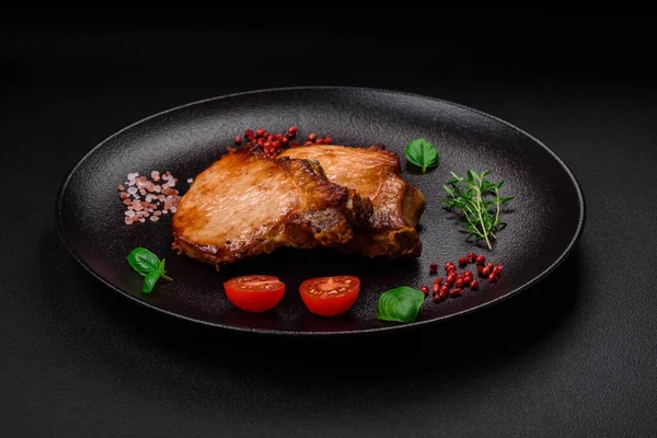 stock image Delicious juicy pork or beef steak with salt, spices and herbs on a textured concrete background