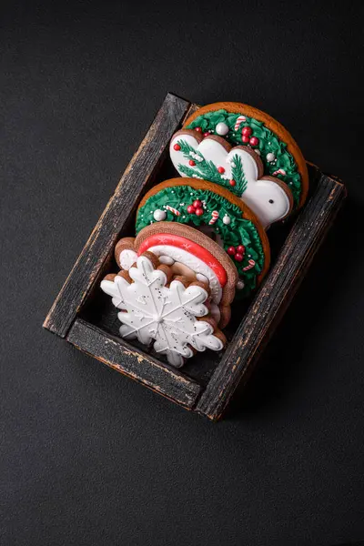 美味新鲜多彩的圣诞或新年姜饼放在深色混凝土背景的瓷盘上 — 图库照片
