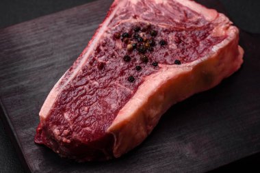 Taze taze taze taze New York bifteği, tuz, baharat ve çimento arka planda otlar.