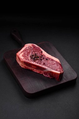 Taze taze taze taze New York bifteği, tuz, baharat ve çimento arka planda otlar.