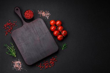 Koyu beton zeminde domates, tuz, baharat ve otlar pişirmek için gerekli malzemeler.