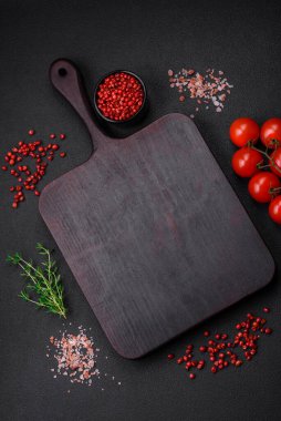 Koyu beton zeminde domates, tuz, baharat ve otlar pişirmek için gerekli malzemeler.