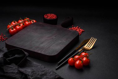 Koyu beton zeminde domates, tuz, baharat ve otlar pişirmek için gerekli malzemeler.