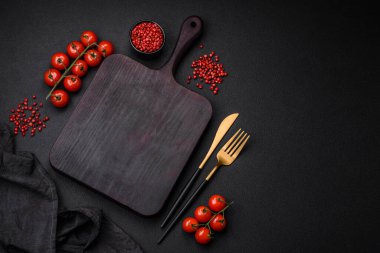 Koyu beton zeminde domates, tuz, baharat ve otlar pişirmek için gerekli malzemeler.