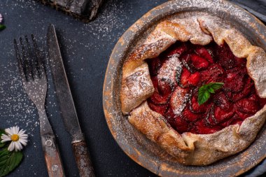 Koyu dokulu arka planda yabani çiçeklerle ev yapımı lezzetli, ev yapımı, kır çileği turtası.