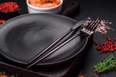 Çeri domates, karides, tuz ve baharat pişirmek için gerekli malzemeler. Koyu beton arka planda bir yazı için bir yer.