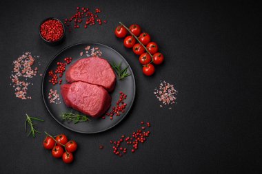 Tuz, baharat ve otlarla çevrili çiğ biftek, dokulu bir arka planda ızgara için hazırlandı.