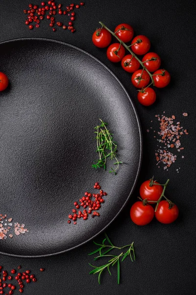 stock image Ingredients for cooking cherry tomatoes, salt, spices and herbs on a dark concrete background