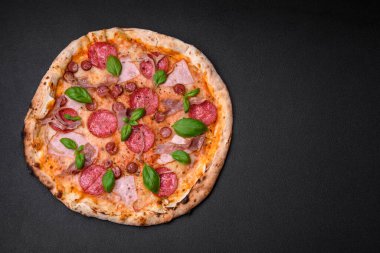 Salamlı, etli, peynirli, domatesli, baharatlı ve çimento kaplı lezzetli fırın fırınlanmış pizza.