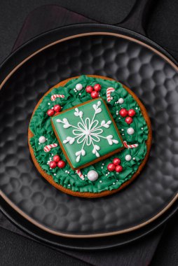 Güzel Noel ya da yeni yıl renkli ev yapımı zencefilli kurabiyeler seramik tabakta koyu beton arka planda