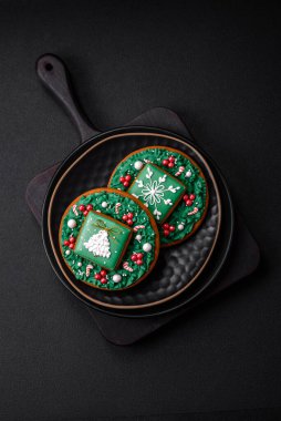 Güzel Noel ya da yeni yıl renkli ev yapımı zencefilli kurabiyeler seramik tabakta koyu beton arka planda