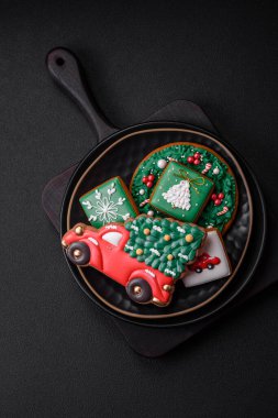 Güzel Noel ya da yeni yıl renkli ev yapımı zencefilli kurabiyeler seramik tabakta koyu beton arka planda