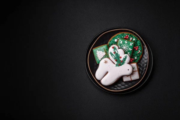 精美的圣诞或新年彩绘的自制姜饼放在深色混凝土背景的瓷盘上 — 图库照片
