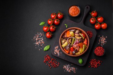 Domatesli taze vejetaryen salatası, yeşil fasulye, patlıcan, biber, tuz, baharat ve otlar koyu beton arka planda.