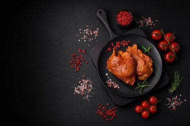 Lezzetli kızarmış ya da tütsülenmiş tavuk butları. Koyu beton bir arka planda baharat ve otlarla ızgara.