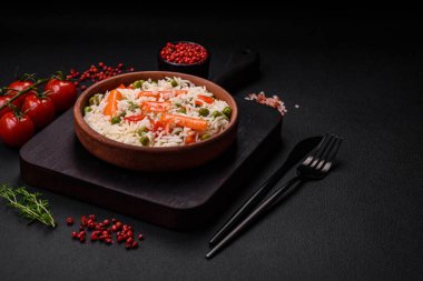 Lezzetli, sebzeli haşlanmış pirinç ya da koyu beton arka planda seramik bir tabakta tuzlu, baharatlı ve otlu risotto.