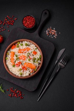 Lezzetli, sebzeli haşlanmış pirinç ya da koyu beton arka planda seramik bir tabakta tuzlu, baharatlı ve otlu risotto.