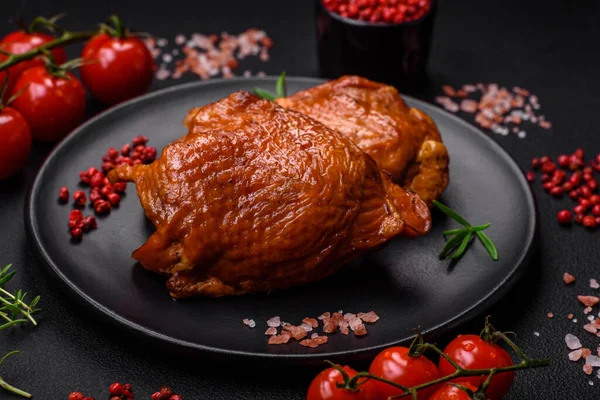 stock image Delicious fried or smoked chicken thighs grilled with spices and herbs on a dark concrete background