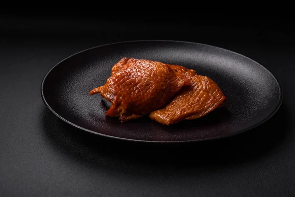 stock image Delicious fried or smoked chicken thighs grilled with spices and herbs on a dark concrete background