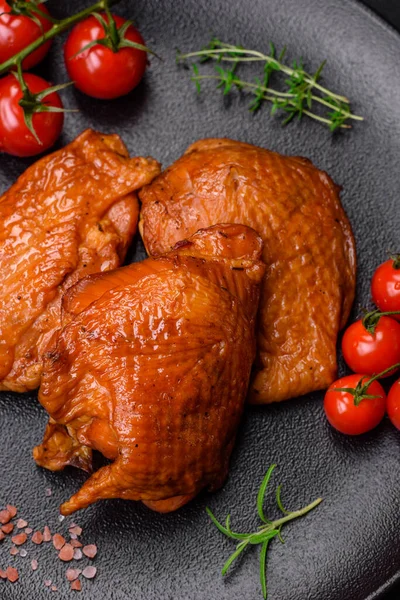 stock image Delicious fried or smoked chicken thighs grilled with spices and herbs on a dark concrete background