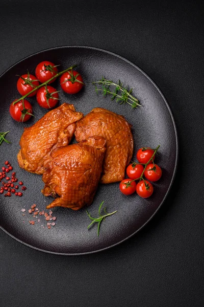 stock image Delicious fried or smoked chicken thighs grilled with spices and herbs on a dark concrete background