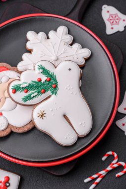 Koyu beton bir zeminde seramik tabakta ev yapımı zencefilli kurabiyeler.