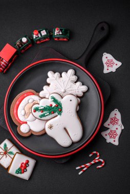 Koyu beton bir zeminde seramik tabakta ev yapımı zencefilli kurabiyeler.