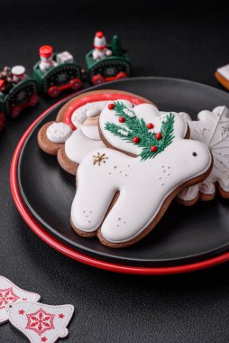 Koyu beton bir zeminde seramik tabakta ev yapımı zencefilli kurabiyeler.