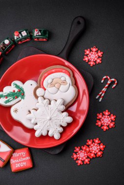 Koyu beton bir zeminde seramik tabakta ev yapımı zencefilli kurabiyeler.