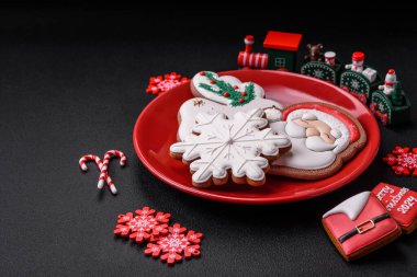 Koyu beton bir zeminde seramik tabakta ev yapımı zencefilli kurabiyeler.