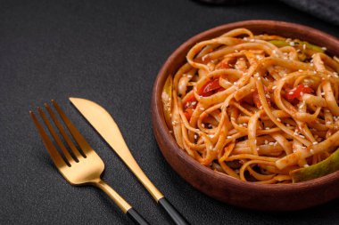 Sebzeli, mantarlı, tuzlu ve baharatlı lezzetli Asya udonu tabağı koyu beton arka planda.