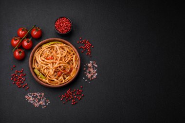 Sebzeli, mantarlı, tuzlu ve baharatlı lezzetli Asya udonu tabağı koyu beton arka planda.