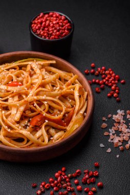 Sebzeli, mantarlı, tuzlu ve baharatlı lezzetli Asya udonu tabağı koyu beton arka planda.